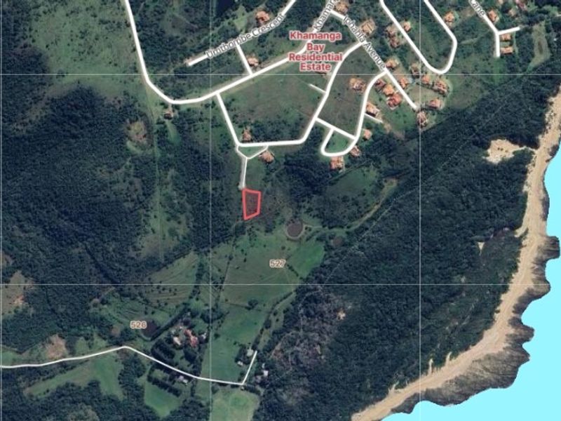 Aerial view of a vacant residential land plot located within the Khamanga Bay Residential Estate, showing surrounding landscape and coastal proximity.