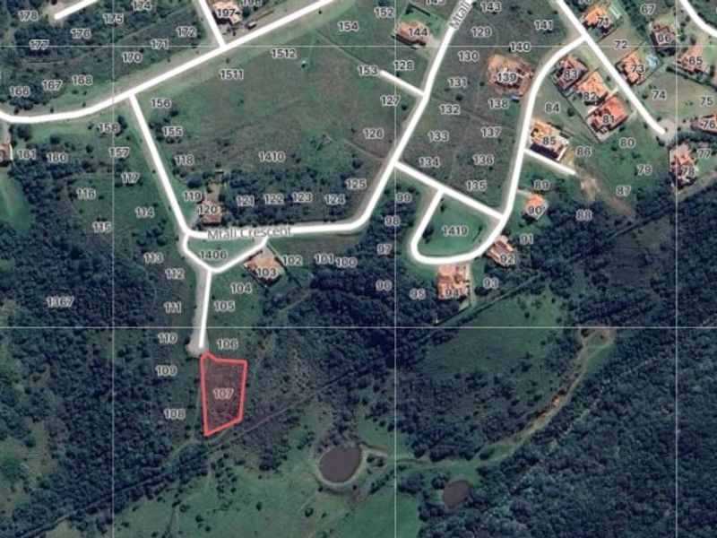 Aerial view of a vacant residential land plot highlighted in red, situated within a developed estate with established road access.