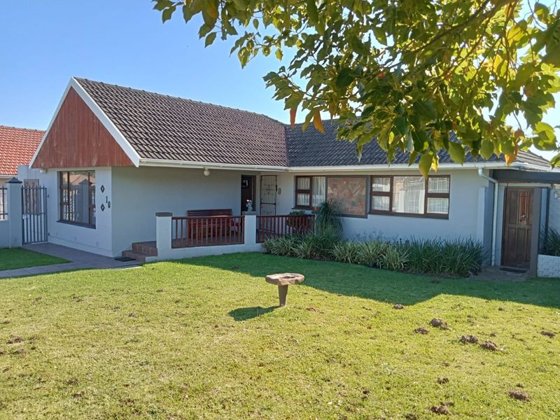 Front view of a single-story residential house featuring a tiled roof, timber gable detail, and a covered porch area with a front lawn.
