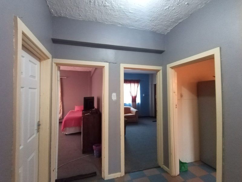 A central hallway providing access to multiple rooms, featuring standard door frames and a textured ceiling finish.