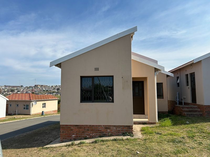 A single-story residential house featuring a pitched roof, brick plinth, and security bars on the windows, situated in a suburban neighborhood.
