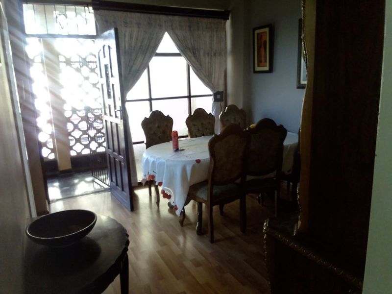 Dining area featuring laminate flooring and direct access to an outdoor space through a security gate.