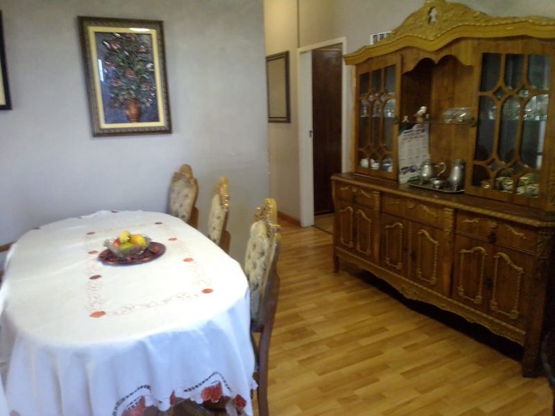 A dining room featuring laminate flooring and neutral wall finishes, providing a functional space for family meals.