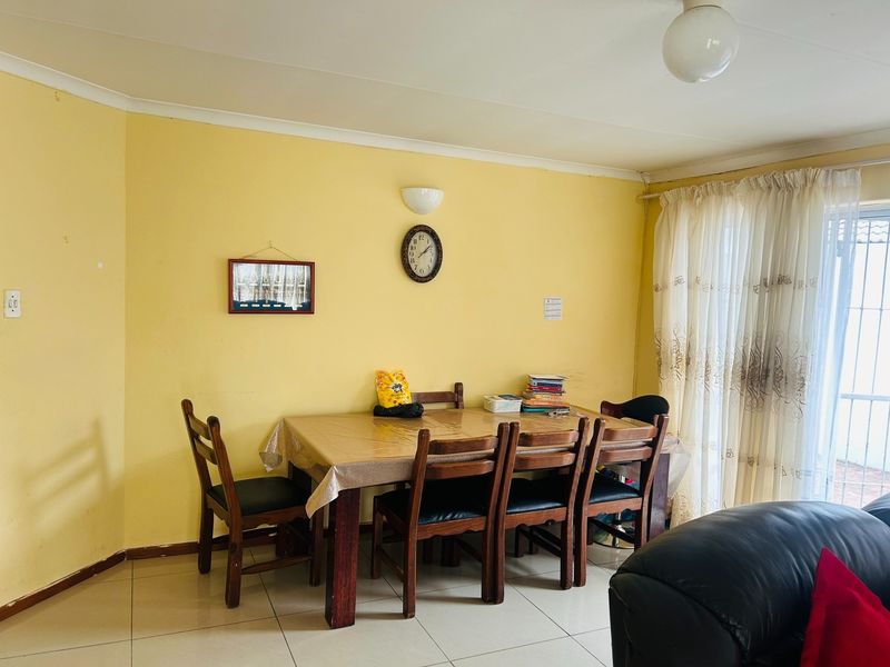 A dining area featuring tiled flooring, cove cornicing, and a sliding glass door providing access to the exterior.
