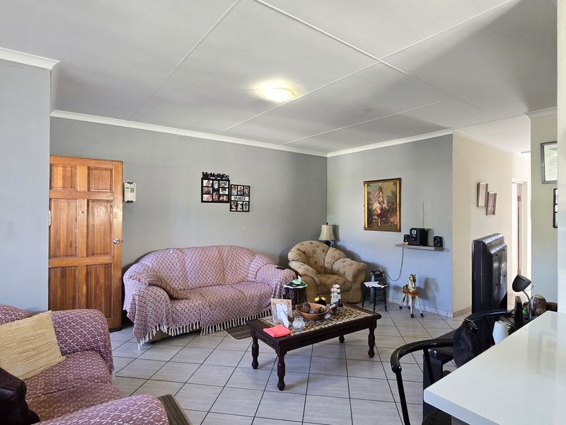 A spacious living room featuring tiled flooring and a coved ceiling, providing a functional and comfortable area for relaxation.