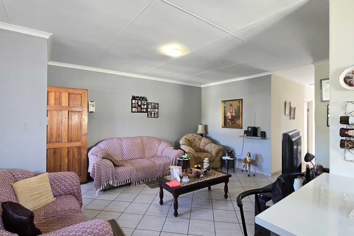 A spacious living room featuring tiled flooring and a coved ceiling, providing a functional and comfortable area for relaxation.