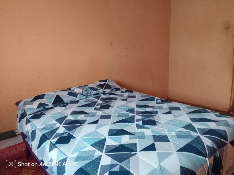 A simple bedroom featuring plain walls, suitable for a refresh or redecoration to enhance the living space.
