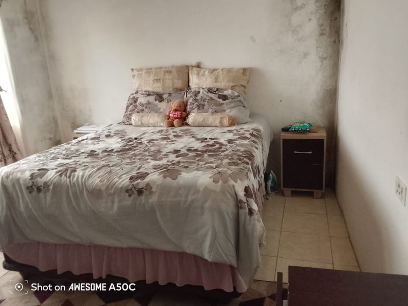 A bedroom featuring tiled flooring and significant wall damage requiring maintenance and cosmetic repair.