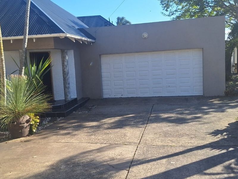 Front exterior view of the house featuring a concrete driveway, a single garage door, and a covered entrance area.