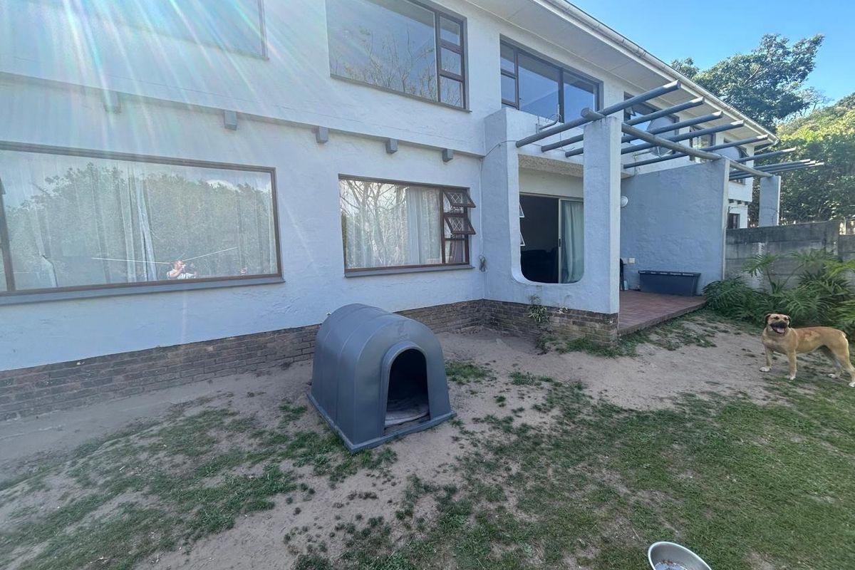 Rear elevation of the townhouse featuring a covered patio area with a pergola, large windows, and a private garden space.