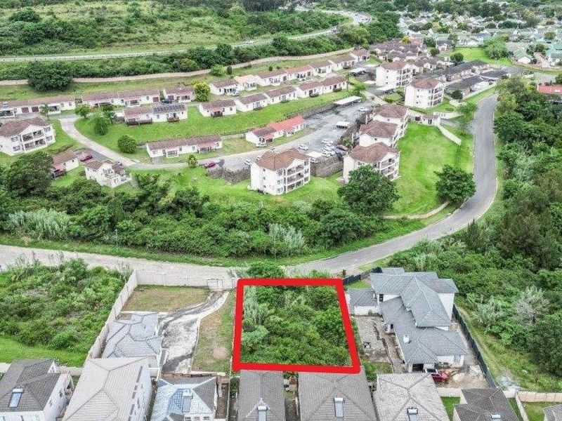 An aerial view of a vacant residential plot highlighted in red, situated within an established suburban estate with surrounding residential properties.