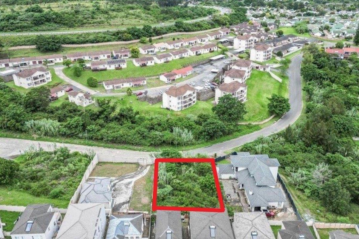 An aerial view of a vacant residential plot highlighted in red, situated within an established suburban estate with surrounding residential properties.