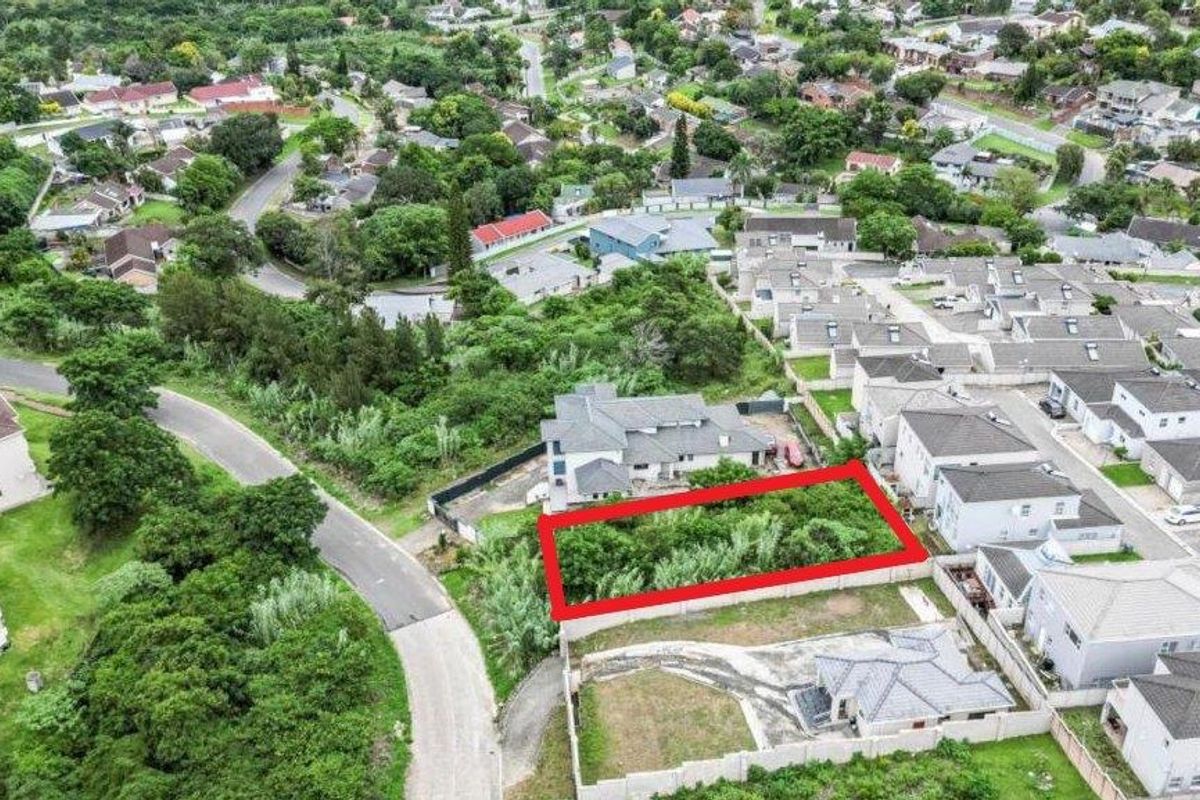 Aerial view of a vacant residential plot situated within an established suburban neighborhood, offering potential for new development.