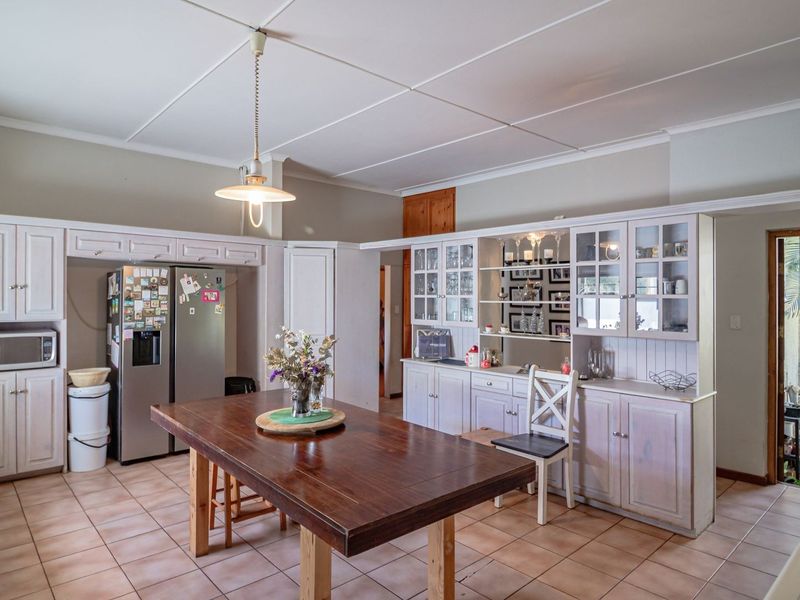 Spacious kitchen featuring traditional built-in cabinetry, tiled flooring, integrated oven and microwave, and a central wooden island, offering a functional layout with ample storage.