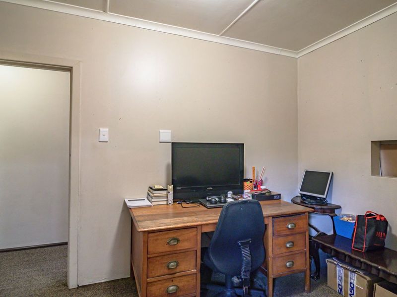 A functional office space featuring a recessed wall niche and coved ceiling, offering a blank canvas for potential renovation or home workspace improvement.