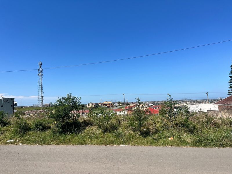 A view from the vacant residential land overlooking the surrounding neighborhood, featuring a telecommunications tower and overhead power lines.