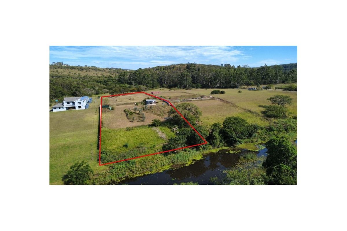 Aerial view of a residential vacant land plot featuring defined boundaries, natural vegetation, and proximity to a water feature.