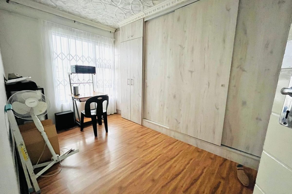 Bedroom featuring laminate flooring, decorative ceiling details, and extensive built-in cupboard storage space.