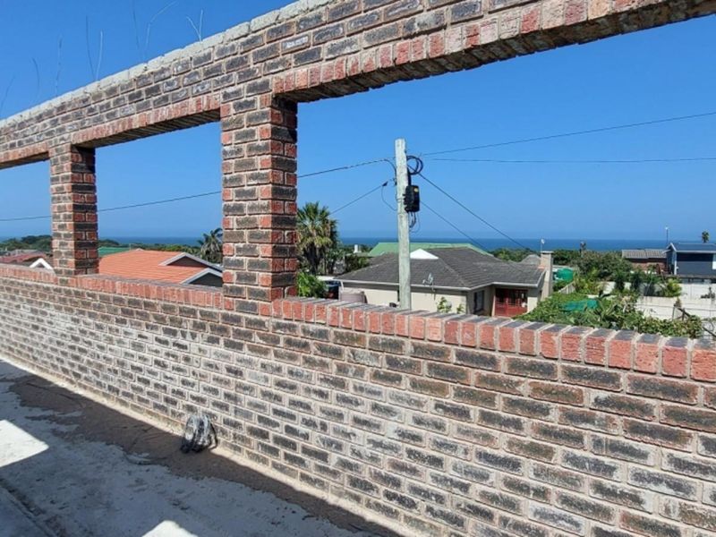 An unfinished elevated balcony or terrace featuring exposed brickwork and expansive coastal views, currently in a shell construction state.
