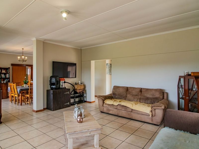 Spacious open-plan living and dining area featuring neutral wall tones and consistent tiled flooring throughout the connected living spaces.