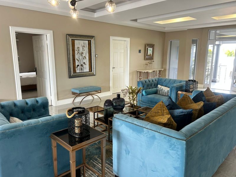 Spacious living room featuring recessed ceiling lighting, neutral wall tones, and polished tiled flooring, providing a bright and well-maintained living environment.