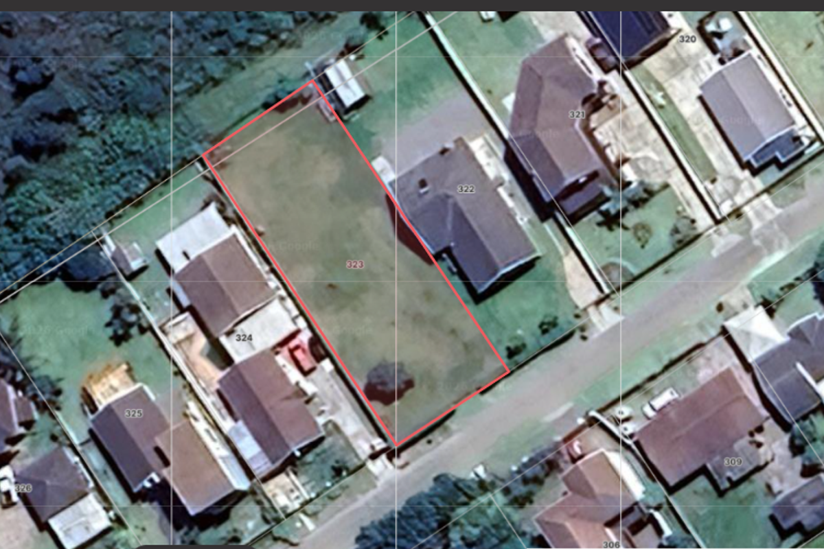 Aerial view of a vacant residential land plot outlined in red, situated within an established suburban neighborhood.
