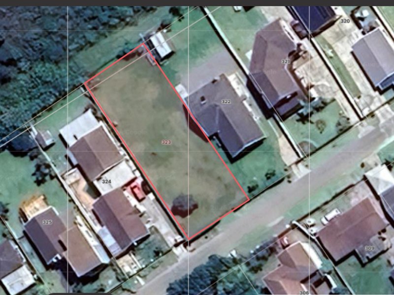 Aerial view of a vacant residential land plot outlined in red, situated within an established suburban neighborhood.