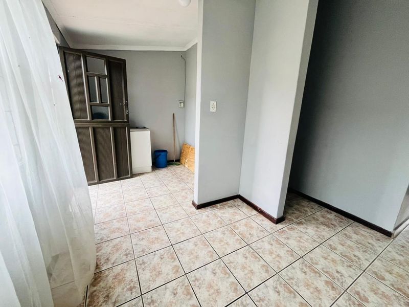 A functional utility or transition space featuring tiled flooring and a secure external door, offering a clean and neutral canvas for various uses.