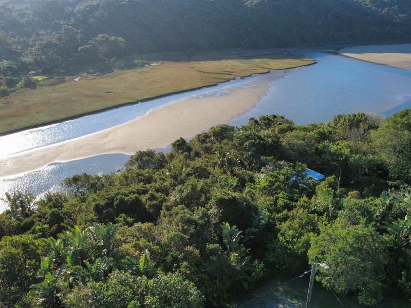 An aerial view showcasing the natural landscape, river, and surrounding lush vegetation near the property.