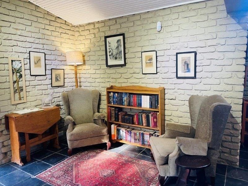 A cozy living area featuring exposed brick walls, dark tiled flooring, and a beaded ceiling, creating a rustic and traditional atmosphere.