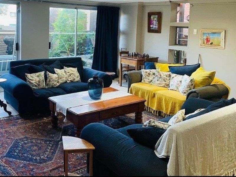 A comfortable living room featuring large sliding glass doors that provide natural light and access to the outdoor area, complemented by built-in wall shelving.