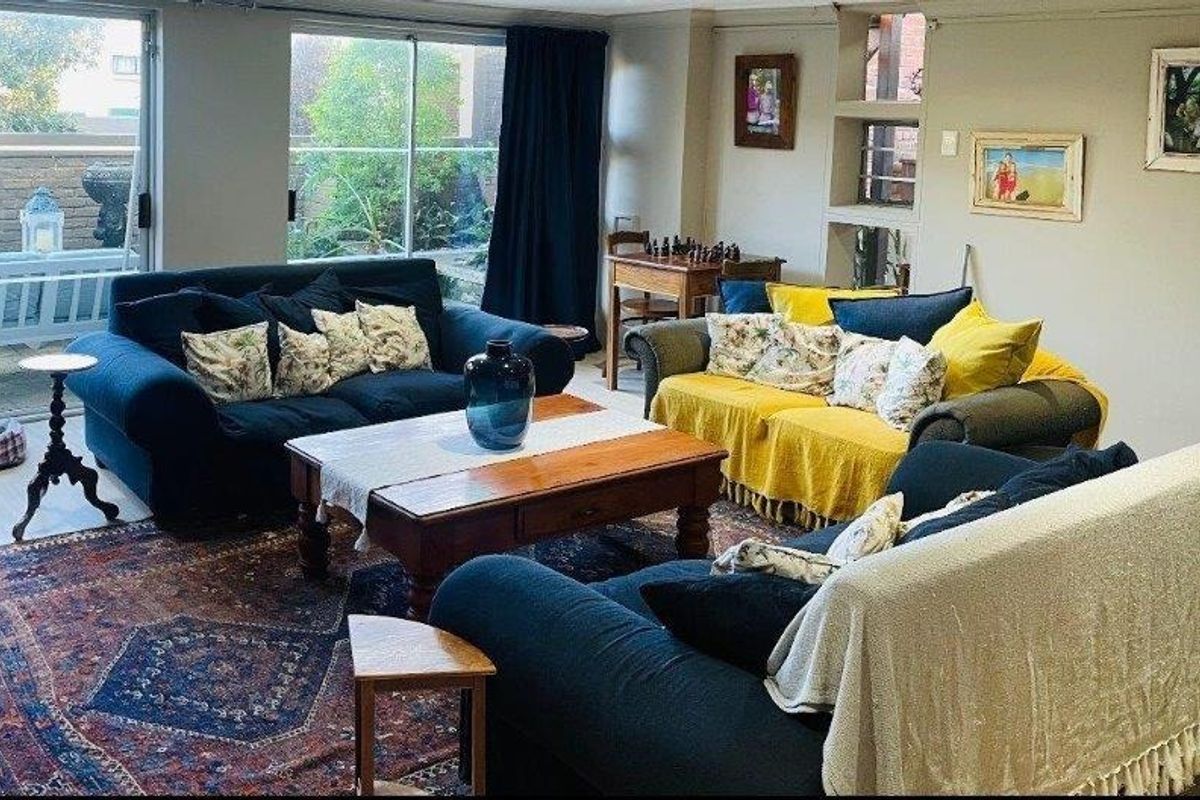 A comfortable living room featuring large sliding glass doors that provide natural light and access to the outdoor area, complemented by built-in wall shelving.