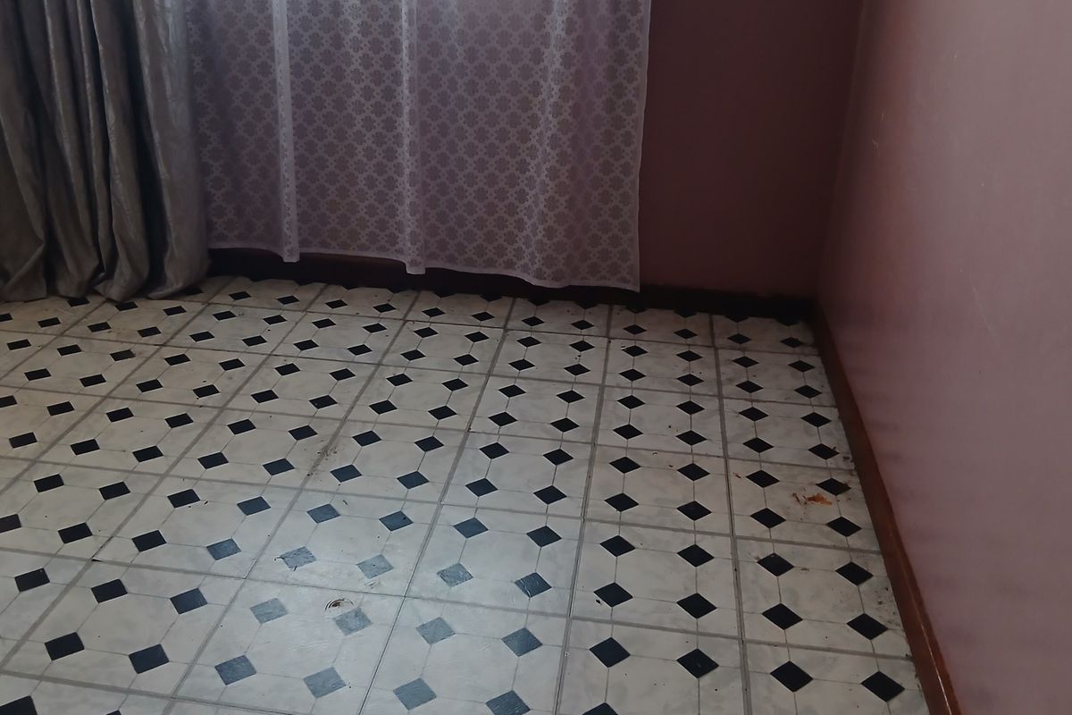 An empty bedroom featuring classic black and white patterned floor tiles and simple wall finishes, ready for renovation or restyling.