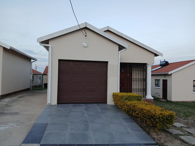 Front view of a single-story residential house featuring a single garage, tiled driveway, and secure entrance.