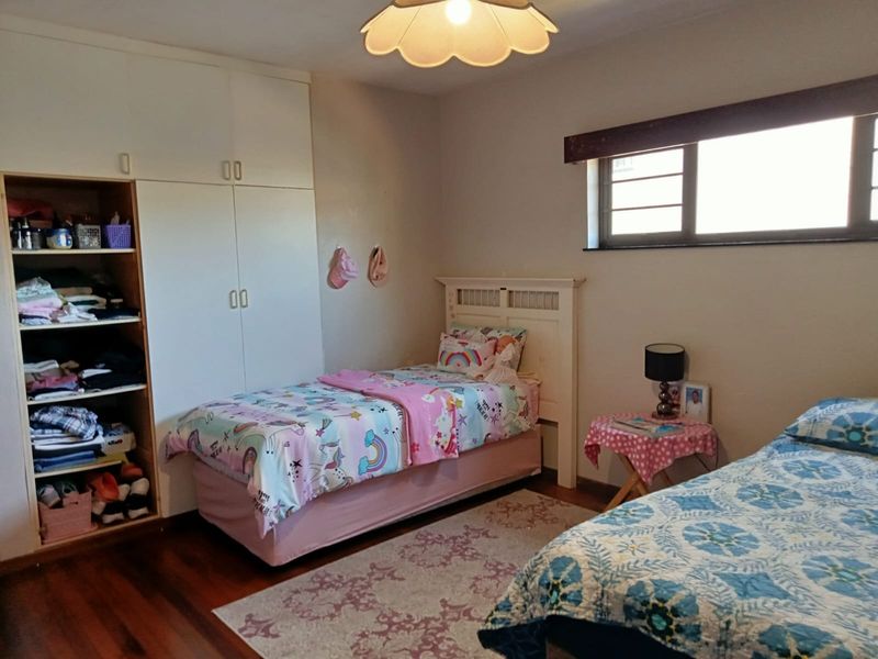 A bedroom featuring wooden flooring and built-in cupboards, providing functional storage space within the apartment.