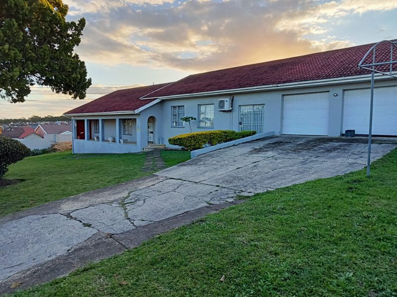 Front elevation of a single-story house featuring a double garage, concrete driveway, and a covered porch area.