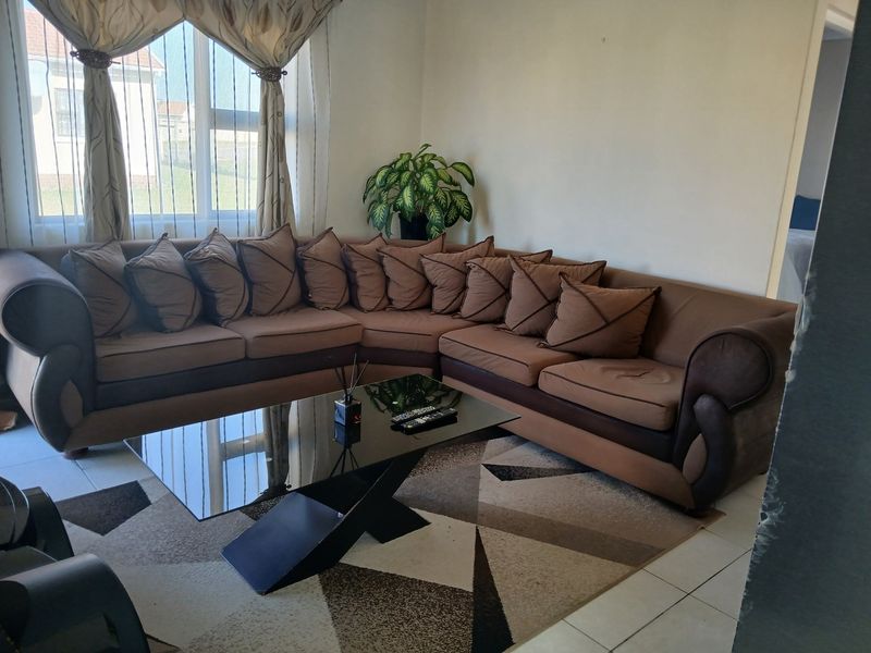 A comfortable living room featuring tiled flooring and a large window that allows for natural light.