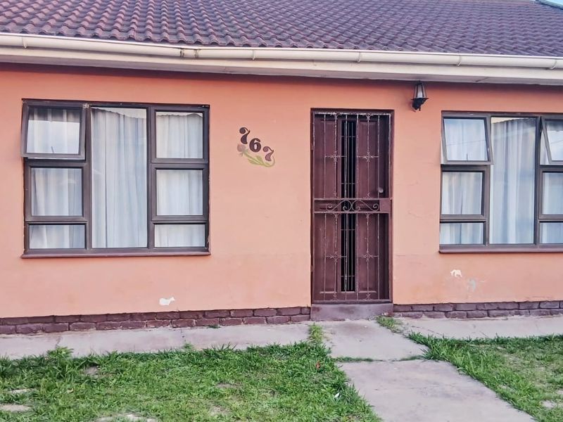 Front facade of a single-story house featuring a tiled roof, aluminium window frames, and a security gate entrance.