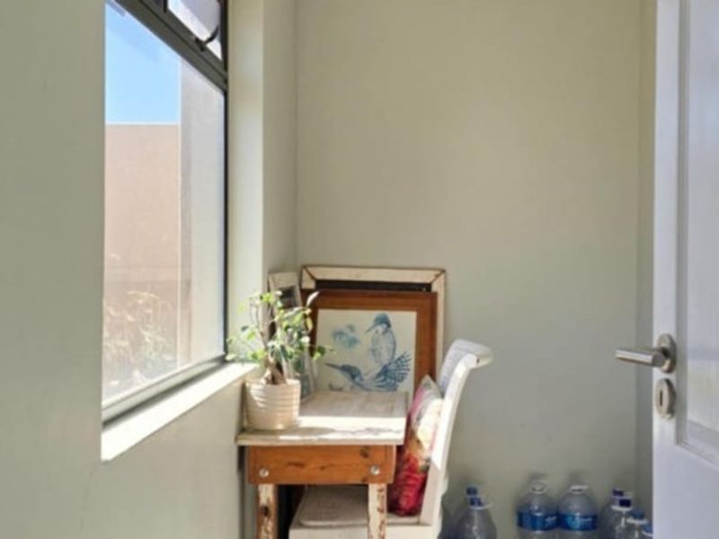 A small utility space or nook featuring a window and door, suitable for a home office or storage area.