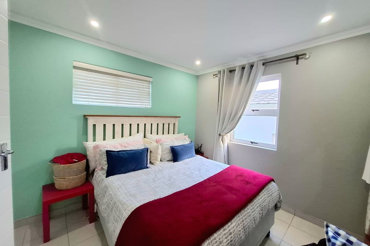 A well-maintained bedroom featuring tiled flooring, recessed downlighting, and natural light provided by a window with fitted blinds and curtain hardware.