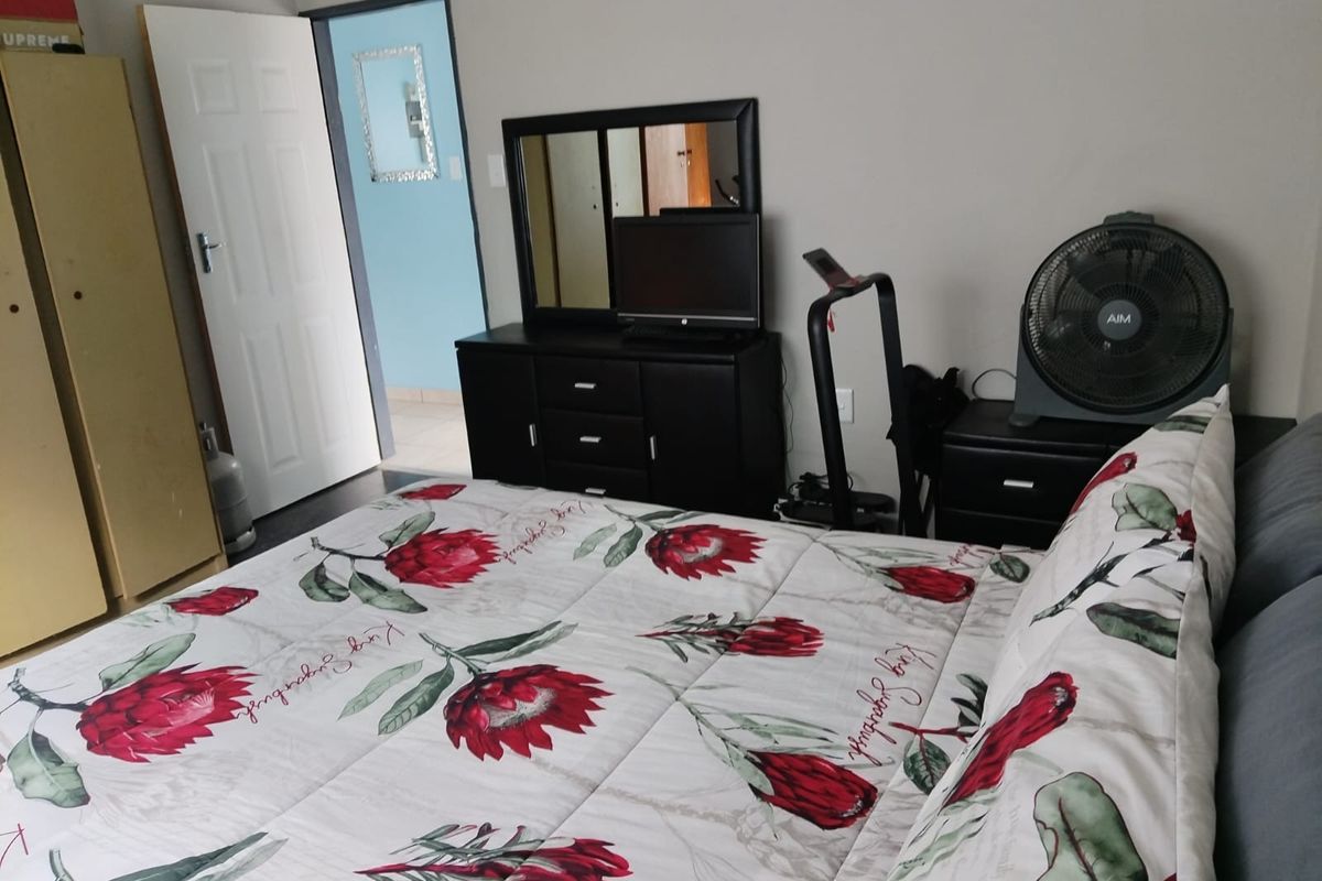A standard bedroom featuring neutral wall finishes and a doorway leading to an adjacent room.