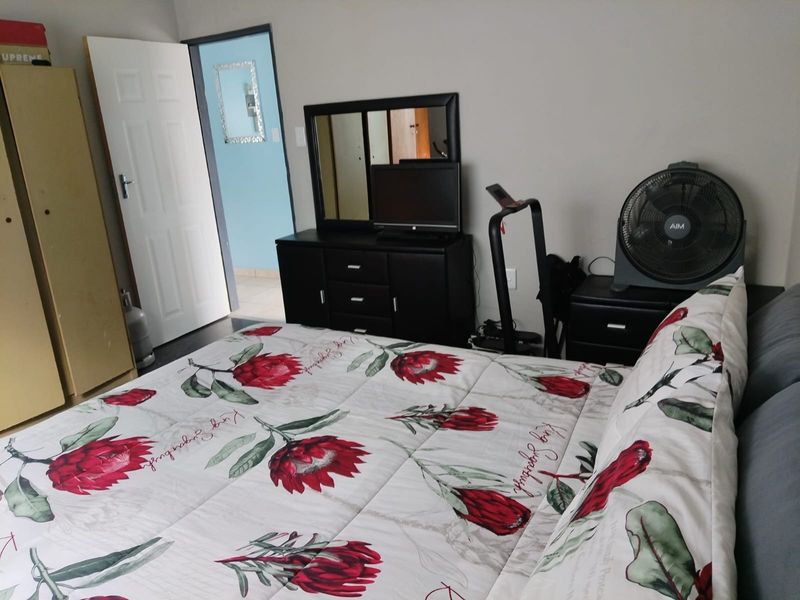 A standard bedroom featuring neutral wall finishes and a doorway leading to an adjacent room.