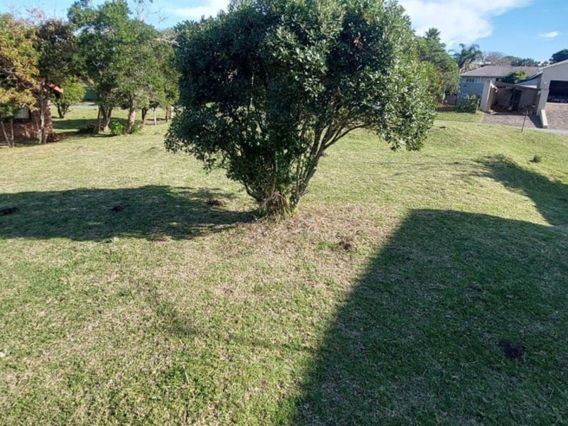 A spacious, well-maintained residential garden featuring established trees and a level lawn area, providing a pleasant outdoor space.