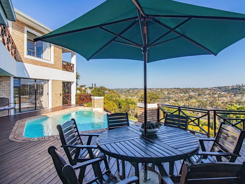 Outdoor pool area featuring timber decking, a swimming pool, and a timber balustrade with expansive elevated views.