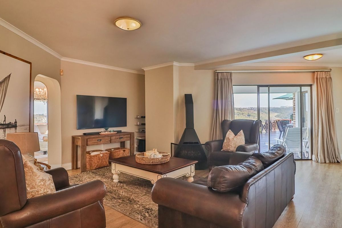 Spacious living room featuring a modern freestanding fireplace, laminate flooring, and large sliding glass doors that provide access to an outdoor patio area.