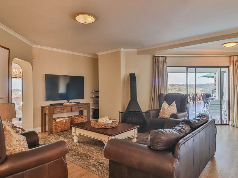 Spacious living room featuring a modern freestanding fireplace, laminate flooring, and large sliding glass doors that provide access to an outdoor patio area.