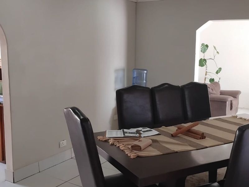 Dining area featuring tiled flooring and an arched entryway leading to the kitchen, with neutral wall finishes throughout.