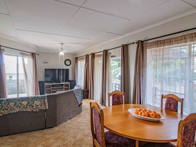 Spacious open-plan living and dining area featuring large sliding glass doors that provide ample natural light and access to the exterior.