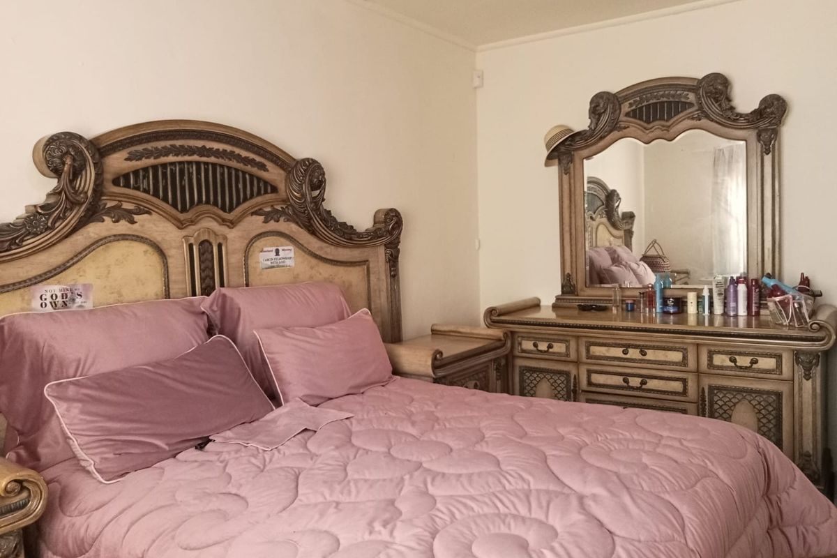 A standard bedroom featuring neutral wall finishes and basic architectural elements, suitable for personalization or modern updates.