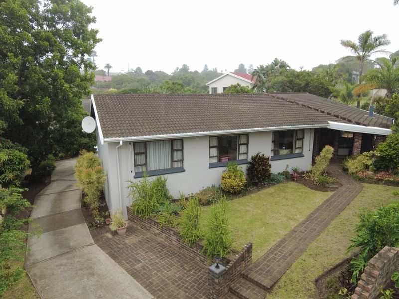 Aerial view of a single-story residential property featuring a tiled roof, concrete driveway, and landscaped front garden with brick paved pathways.
